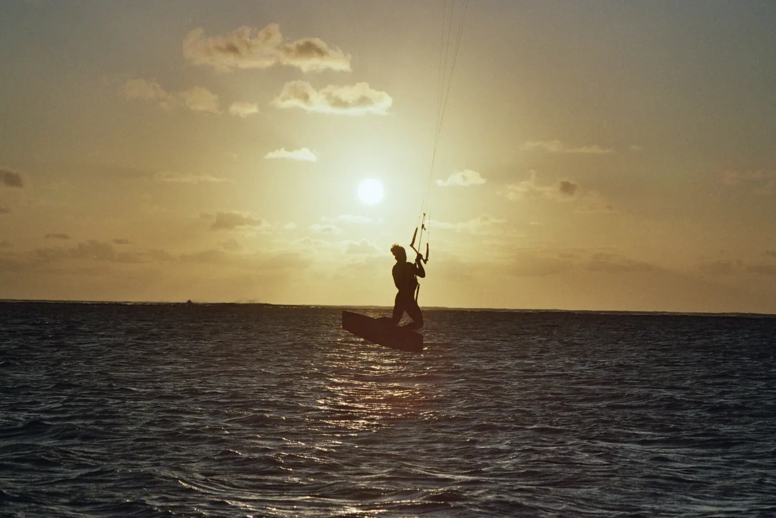Kitesurfeur en silhouette au coucher de soleil sur le lagon du Morne, île Maurice